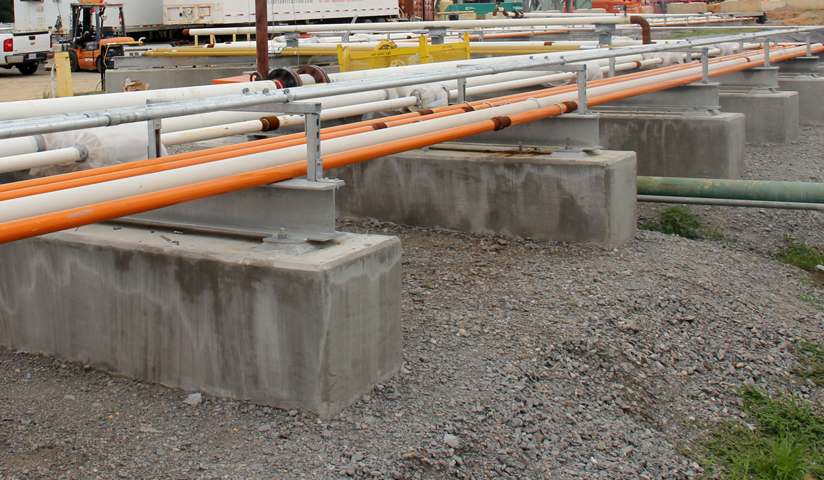 Insulated process pipes on concrete sleeper supports with guides at an industrial pipe rack